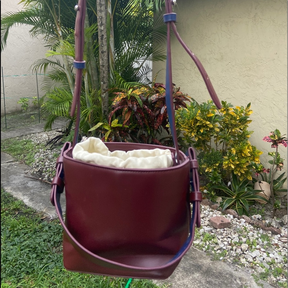 Burgundy box satchel with sack inside.